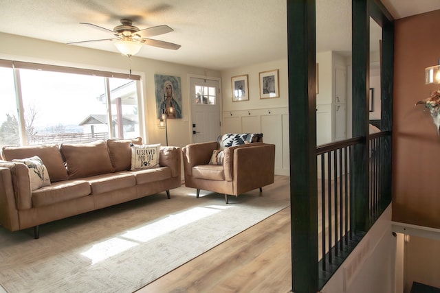 living area with light wood-style flooring and ceiling fan