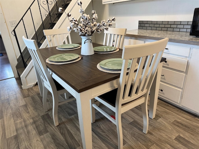 dining space featuring stairway and wood finished floors