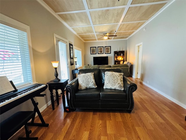 living area featuring a ceiling fan, wood finished floors, baseboards, and coffered ceiling