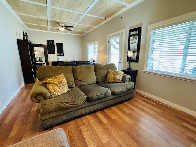 living area with baseboards, coffered ceiling, wood finished floors, and a ceiling fan