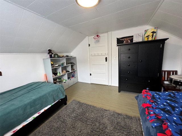 bedroom with hardwood / wood-style floors and vaulted ceiling