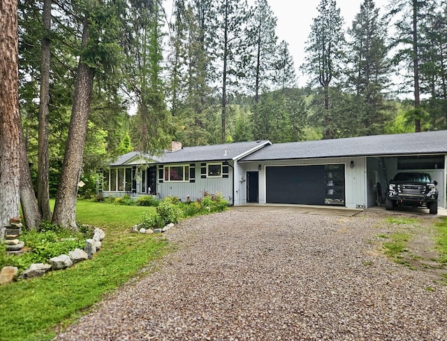 1103 Greers Ferry Rd, Libby, MT 59923 - single story home featuring gravel driveway, an attached garage, a chimney, a front lawn, and a carport