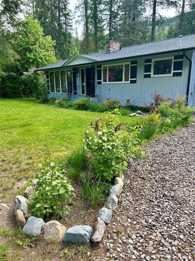 1103 Greers Ferry Rd, Libby, MT 59923 - single story home featuring a chimney, a front lawn, and a sunroom