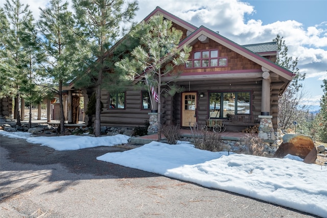 view of front facade featuring covered porch and log exterior