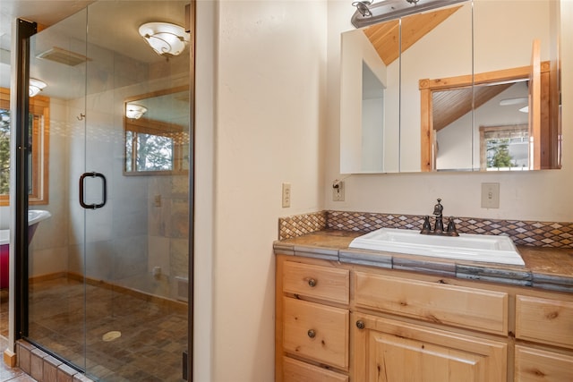 bathroom with vanity, lofted ceiling, and a stall shower