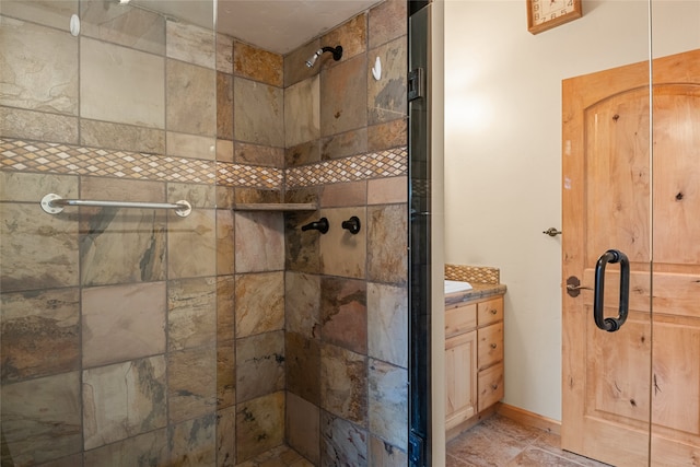 bathroom with vanity, baseboards, and a stall shower