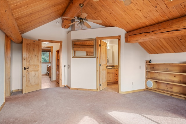 unfurnished bedroom with connected bathroom, baseboards, lofted ceiling with beams, carpet flooring, and wooden ceiling