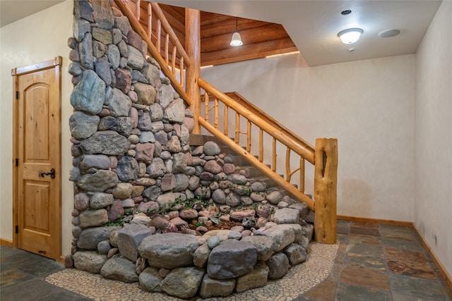 stairs with baseboards and stone tile flooring