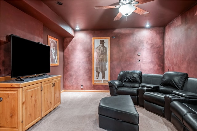 cinema room featuring ceiling fan, baseboards, and light carpet