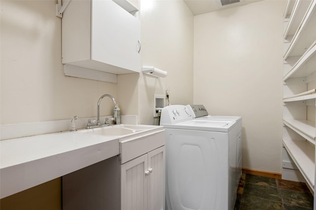 clothes washing area featuring visible vents, cabinet space, a sink, stone finish flooring, and independent washer and dryer