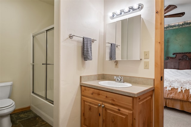 ensuite bathroom featuring toilet, enclosed tub / shower combo, connected bathroom, baseboards, and vanity