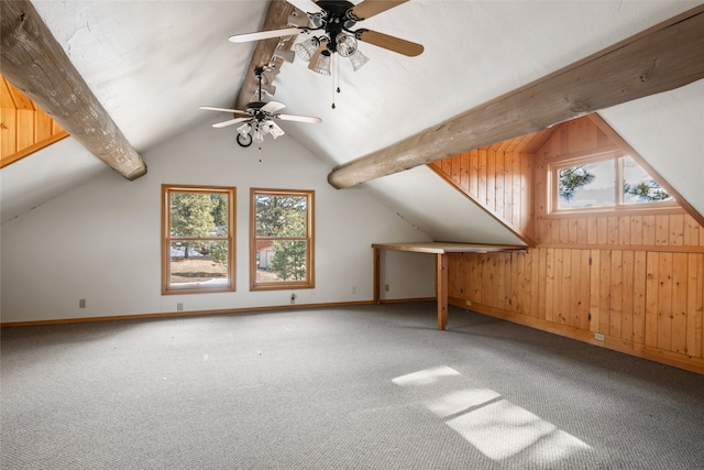 additional living space featuring lofted ceiling with beams, plenty of natural light, carpet, and wood walls