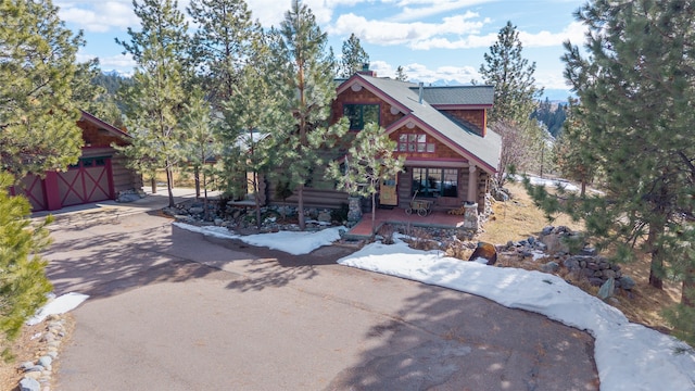 view of front of property with an outdoor structure, a garage, and driveway