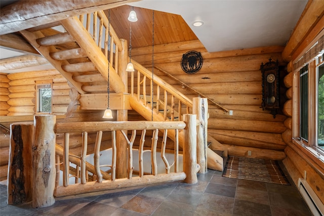 stairway featuring stone finish flooring, baseboard heating, and rustic walls