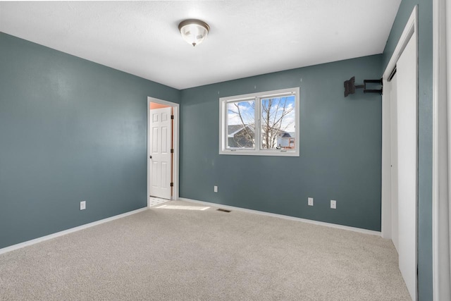 unfurnished bedroom featuring visible vents, baseboards, and carpet