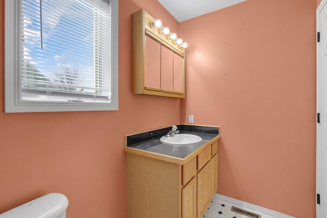 bathroom with vanity, toilet, baseboards, and visible vents