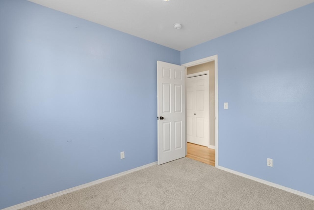 carpeted spare room featuring baseboards