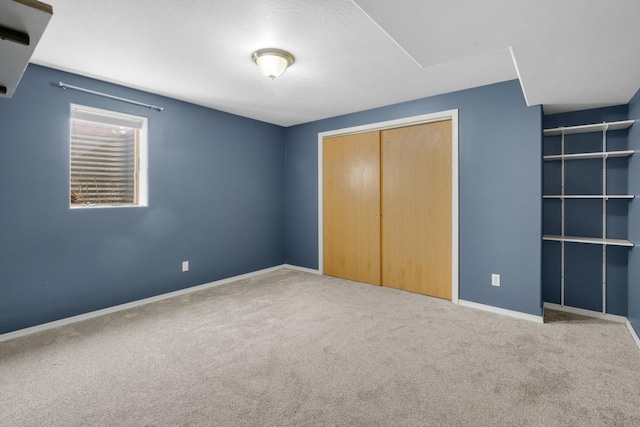 unfurnished bedroom featuring baseboards, carpet floors, and a closet