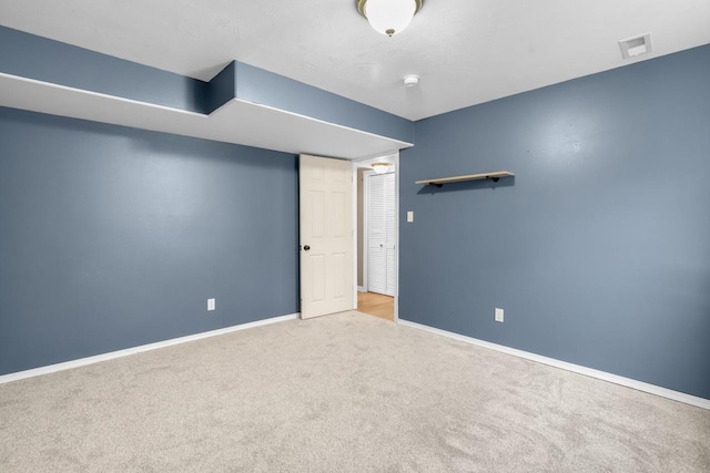 carpeted empty room with visible vents and baseboards