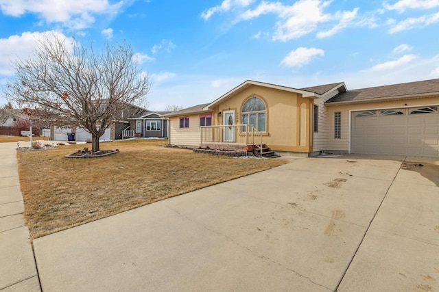 single story home with concrete driveway, a garage, a front lawn, and stucco siding