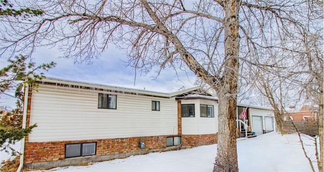 view of snowy exterior featuring a garage