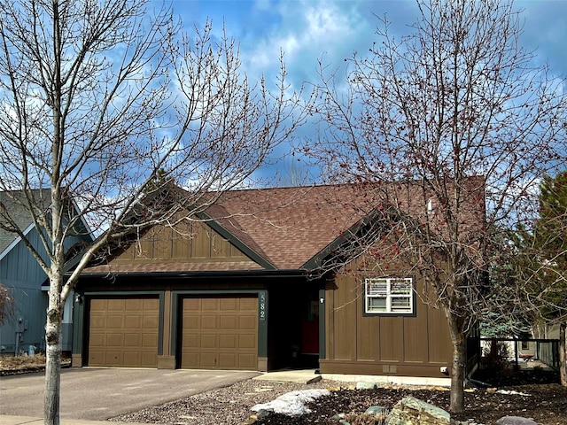 view of front of house featuring aphalt driveway, board and batten siding, roof with shingles, and a garage