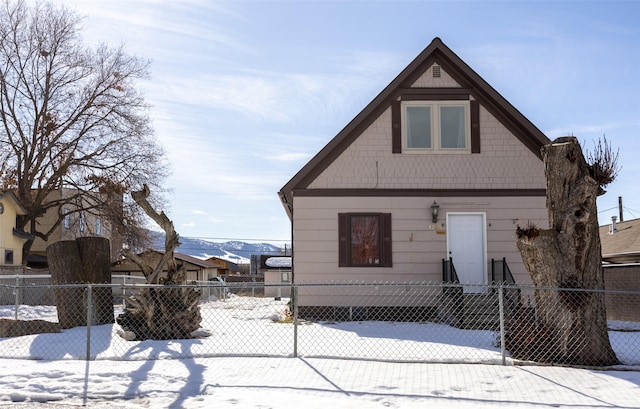 snow covered back of property with a fenced front yard