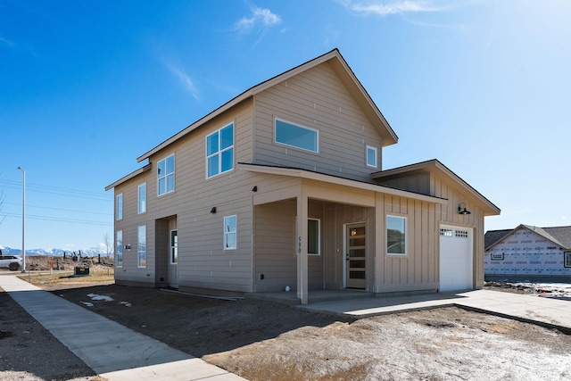 back of property featuring concrete driveway, an attached garage, and board and batten siding