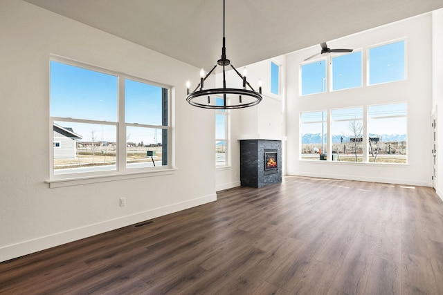590 Stillwater Rd, Kalispell, MT 59901 - unfurnished living room featuring dark wood-style flooring, healthy amount of natural light, a chandelier, a ceiling fan, and a towering ceiling