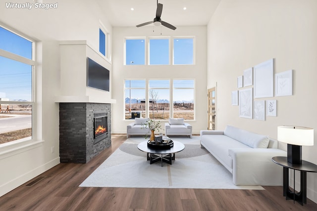 590 Stillwater Rd, Kalispell, MT 59901 - living area with a ceiling fan, a stone fireplace, healthy amount of natural light, a high ceiling, and wood finished floors