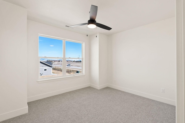 unfurnished room featuring visible vents, ceiling fan, baseboards, and carpet