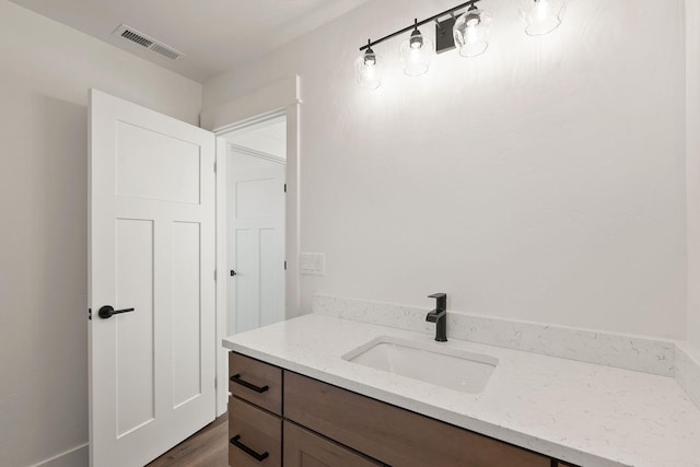 bathroom with visible vents, wood finished floors, and vanity