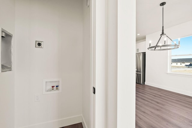 washroom with hookup for an electric dryer, dark wood-type flooring, baseboards, and washer hookup