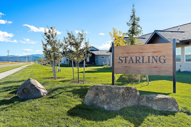 community sign with a lawn and a mountain view