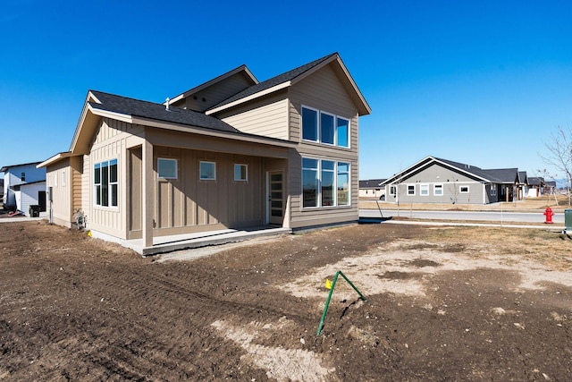 back of house featuring board and batten siding and a residential view