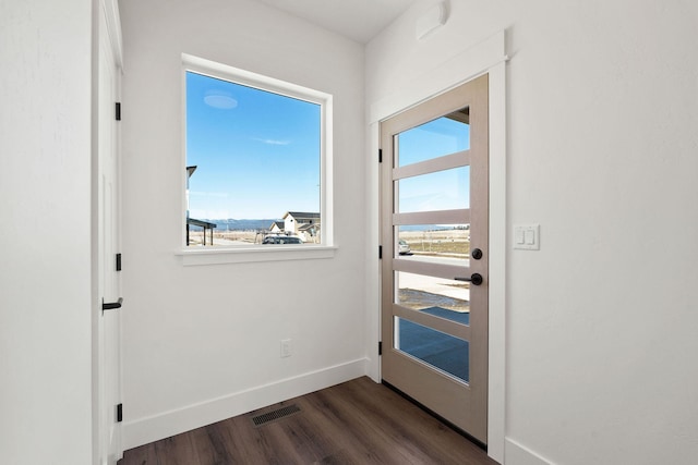 doorway to outside with visible vents, baseboards, and dark wood-style floors