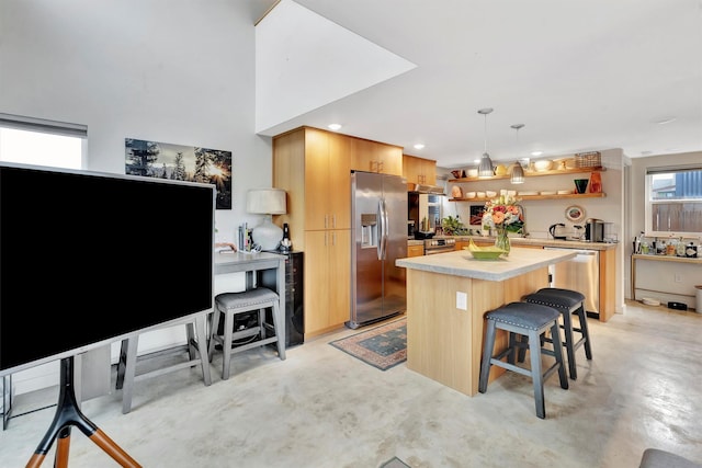 kitchen featuring finished concrete flooring, open shelves, light countertops, appliances with stainless steel finishes, and a center island