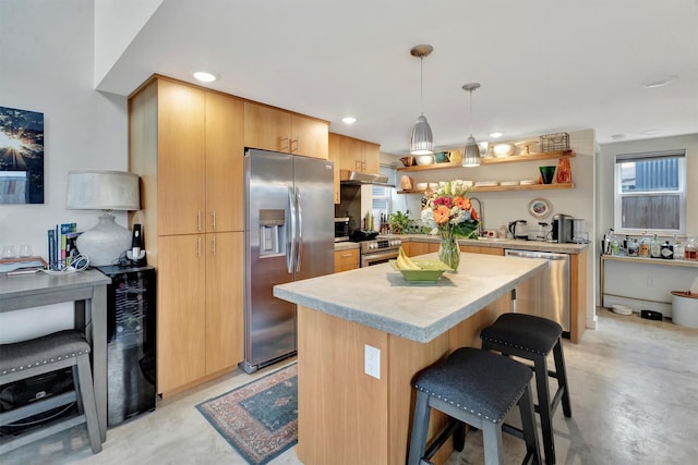 kitchen with pendant lighting, a center island, appliances with stainless steel finishes, a breakfast bar area, and light countertops