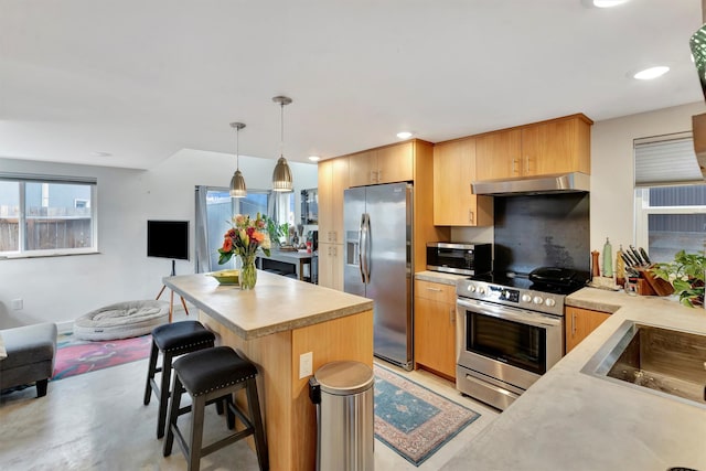 kitchen featuring a kitchen bar, open floor plan, ventilation hood, appliances with stainless steel finishes, and light countertops