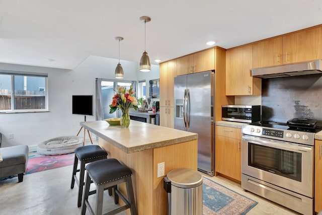 kitchen with tasteful backsplash, a kitchen island, under cabinet range hood, appliances with stainless steel finishes, and a kitchen breakfast bar