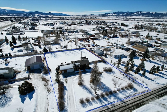 snowy aerial view with a mountain view and a residential view