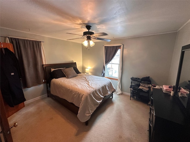 bedroom with light carpet, baseboards, ceiling fan, and ornamental molding