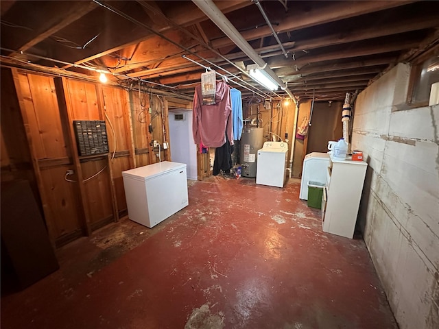 unfinished below grade area featuring fridge, separate washer and dryer, and water heater