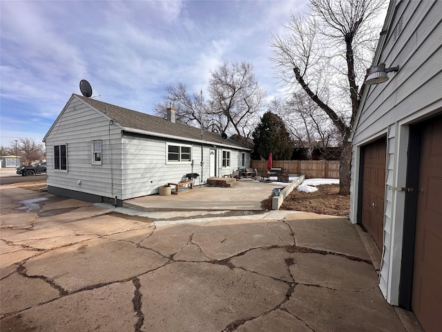 view of property exterior with a patio area and fence