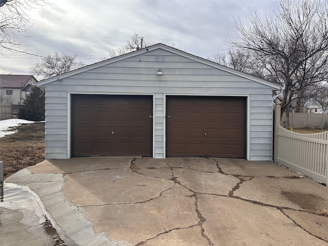 detached garage featuring fence