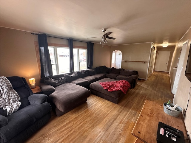 living room featuring arched walkways, ceiling fan, and wood-type flooring