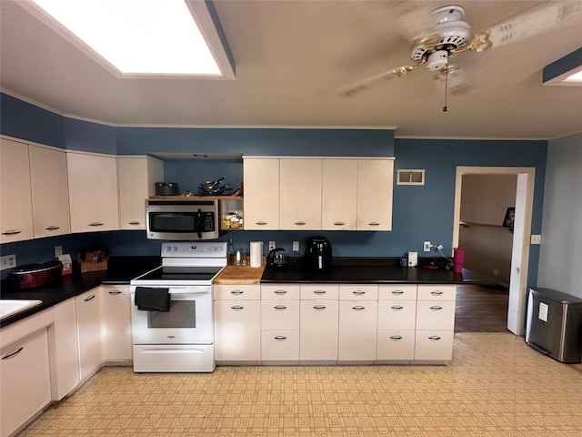 kitchen featuring dark countertops, stainless steel microwave, visible vents, light floors, and white electric range oven