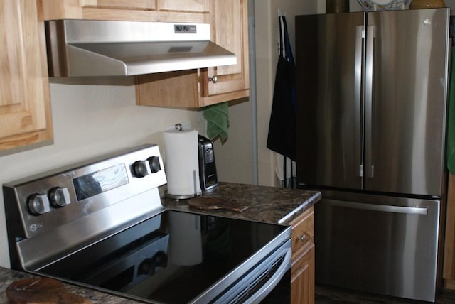 kitchen with under cabinet range hood, dark countertops, and appliances with stainless steel finishes