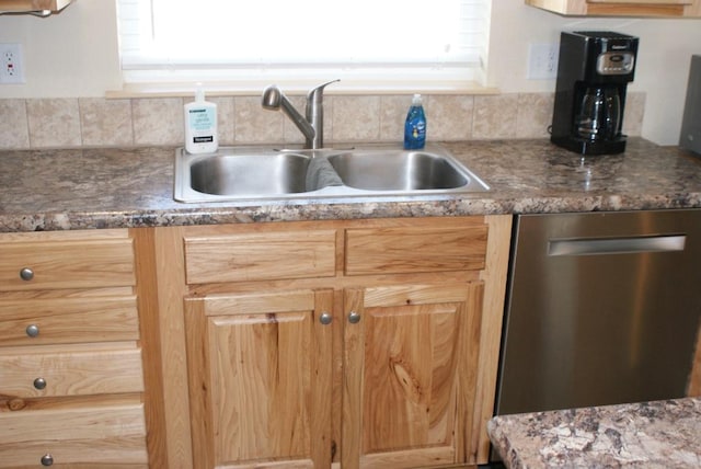 kitchen with dark countertops, backsplash, dishwasher, and a sink