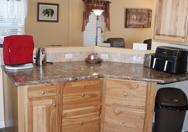 kitchen featuring dark stone counters and light brown cabinets